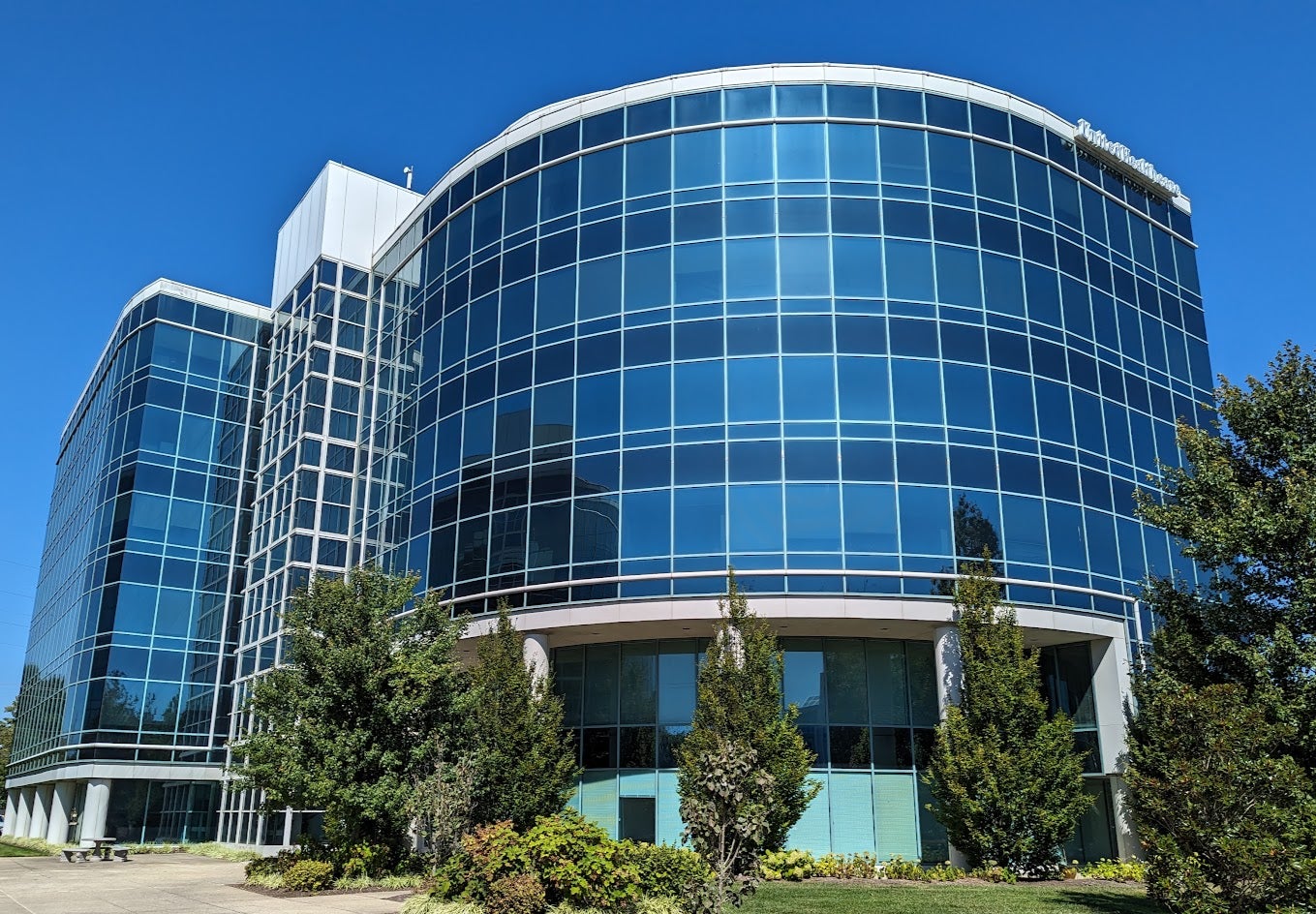 Image of a round glass building with glass towers on either side.
